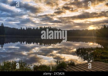 Der kleine Moorsee Etang de la Gruère im Schweizer Kanton Jura. Die Stimmung am Morgen kurz vor und nach Sonnenaufgang Stockfoto