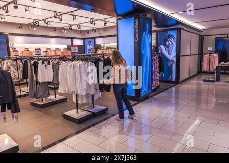 Nahaufnahme einer Frau, die in der Calvin Klein Sektion in Macy's Kaufhaus Kleidung auswählt. New York. USA. Stockfoto