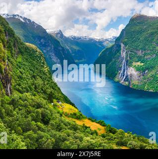 Unglaubliche Aussicht auf das klare azurblaue Wasser des Sunnylvsfjorden Fjord und die berühmten Wasserfälle der Sieben Schwestern in der Nähe des Geiranger Dorfes in Westnorwegen Stockfoto