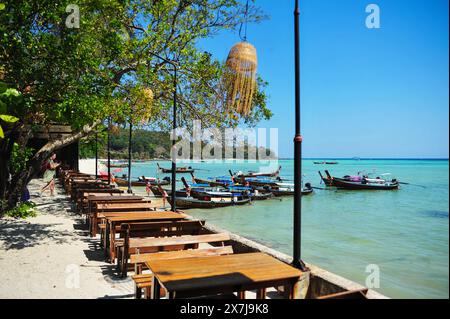 Die atemberaubende Tonsai Bay hat türkisfarbenes Wasser und ist ein Ort für Bootstouren. Fähren kommen und gehen, Yachten ankern, Tauchboote und Tourboote fahren hin und her, die Passagiere oder Güter transportieren. Die Bucht ist fast 2 km von den äußeren Punkten entfernt, mit hohen Klippen, die zu kleinen Stränden mit Affen und Korallenriffen an der Westseite führen. Die Ostseite der Bucht ist flacher, mit großen Korallenflächen und einer Reihe von Stränden und Hotels am Ufer. An der Mündung der Bucht, auf der Ostseite, befindet sich Long Beach und Shark Point, die gegenüber Phi Phi Leh liegen. Thailand. Stockfoto