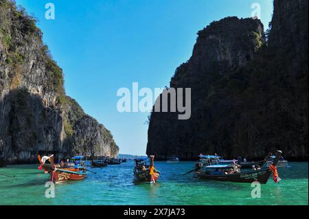 Die atemberaubende Tonsai Bay hat türkisfarbenes Wasser und ist ein Ort für Bootstouren. Fähren kommen und gehen, Yachten ankern, Tauchboote und Tourboote fahren hin und her, die Passagiere oder Güter transportieren. Die Bucht ist fast 2 km von den äußeren Punkten entfernt, mit hohen Klippen, die zu kleinen Stränden mit Affen und Korallenriffen an der Westseite führen. Die Ostseite der Bucht ist flacher, mit großen Korallenflächen und einer Reihe von Stränden und Hotels am Ufer. An der Mündung der Bucht, auf der Ostseite, befindet sich Long Beach und Shark Point, die gegenüber Phi Phi Leh liegen. Thailand. Stockfoto