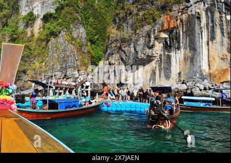 Die atemberaubende Tonsai Bay hat türkisfarbenes Wasser und ist ein Ort für Bootstouren. Fähren kommen und gehen, Yachten ankern, Tauchboote und Tourboote fahren hin und her, die Passagiere oder Güter transportieren. Die Bucht ist fast 2 km von den äußeren Punkten entfernt, mit hohen Klippen, die zu kleinen Stränden mit Affen und Korallenriffen an der Westseite führen. Die Ostseite der Bucht ist flacher, mit großen Korallenflächen und einer Reihe von Stränden und Hotels am Ufer. An der Mündung der Bucht, auf der Ostseite, befindet sich Long Beach und Shark Point, die gegenüber Phi Phi Leh liegen. Thailand. Stockfoto