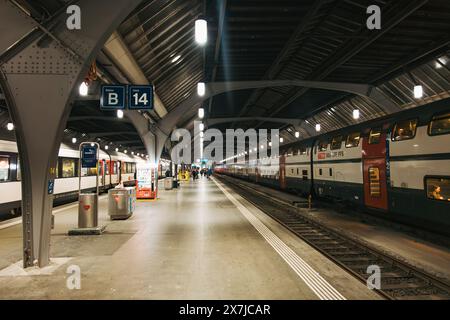 Ein verlassener Bahnsteig im Zürcher Hauptbahnhof, beleuchtet durch Oberlichter, an anderen Bahnsteigen warten SBB-Züge Stockfoto