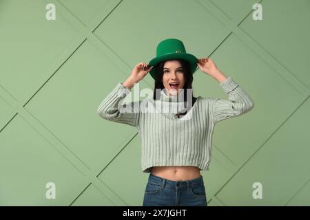 Schöne junge Frau in Kobold Hut auf grünem Hintergrund. St. Patrick's Day-Feier Stockfoto