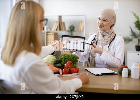 Professionelle Ernährungswissenschaftlerin erzählt den Patienten über die Vorteile einer gesunden Ernährung. Stockfoto