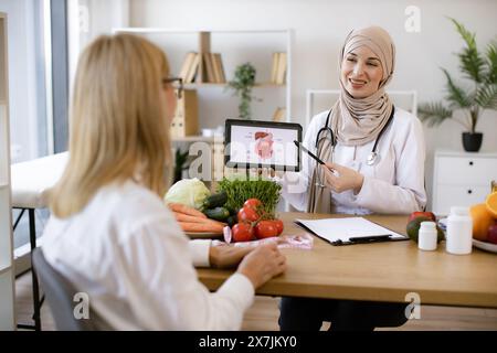 Schöne Erwachsene Frau bei einem Termin mit der Ernährungsberaterin. Stockfoto