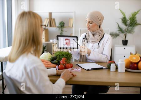 Schöne Erwachsene Frau bei einem Termin mit der Ernährungsberaterin. Stockfoto