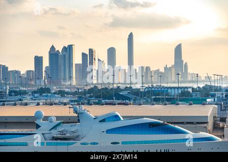 Abu Dhabi, VAE - 4. Januar 2024: Ein Panoramablick auf die Skyline von Abu Dhabi bei Sonnenaufgang, der die moderne Architektur der Stadt und eine Luxusyacht am Andocken zeigt Stockfoto