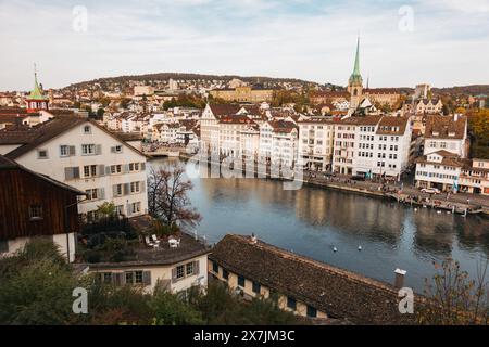 Zürcher Limmat an einem ruhigen Herbsttag mit alten Gebäuden am Ufer und hinter dem Turm der Zentralbibliothek sichtbar Stockfoto