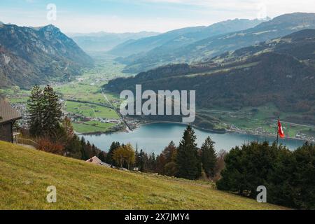 Eine malerische Aussicht von einem grasbewachsenen Hügel mit Blick auf den Walensee und die Gemeinde Walenstadt in der Schweiz. Stockfoto