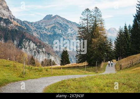 Ein paar Spaziergänge entlang eines gewundenen Pfades durch ein malerisches Tal vor dem Hintergrund der majestätischen Churfirsten in der Schweiz Stockfoto