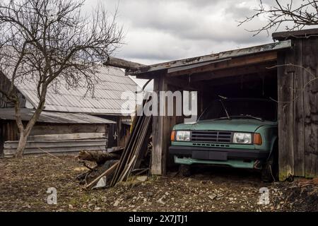 Altes stationäres osteuropäisches Skoda 120-Fahrzeug, das in einem Holzunterstand geparkt ist Stockfoto