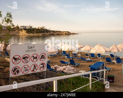 Mai 2024 - Reihen von Sonnenschirmen und Sonnenliegen in der Nähe von Pafos, Zypern. Stockfoto