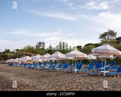 Mai 2024 - Reihen von Sonnenschirmen und Sonnenliegen in der Nähe von Pafos, Zypern. Stockfoto