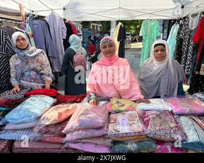 Frauen, die Kleidung auf der Bangladeshi Street Fair im Kensington-Viertel von Brooklyn, New York, verkaufen Stockfoto