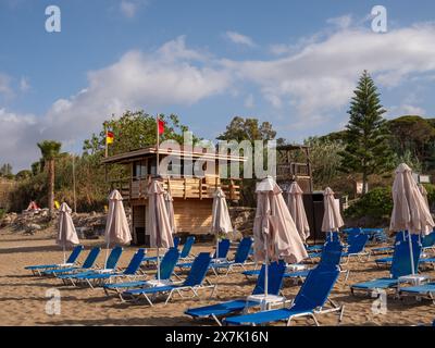 Mai 2024 - Reihen von Sonnenschirmen und Sonnenliegen in der Nähe von Pafos, Zypern. Stockfoto