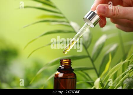 Frau tropft im Freien ätherisches Öl aus der Pipette, Nahaufnahme Stockfoto