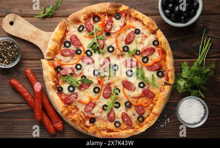 Leckere Pizza und Zutaten auf Holztisch, Blick von oben Stockfoto