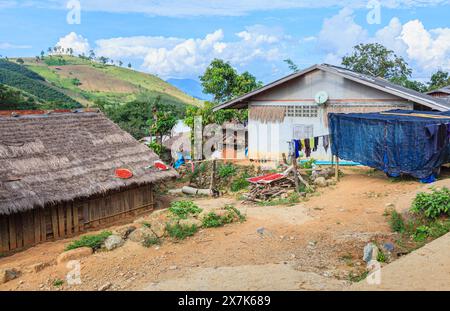 Hellrote Chilis, die in der Sonne auf einem Dach in einem Dorf in Lahu in der Lanjia Lodge in Chiang Khong in der Provinz Chiang Rai im Norden Thailands trocknen Stockfoto