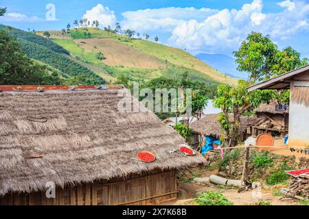 Hellrote Chilis, die in der Sonne auf einem Dach in einem Dorf in Lahu in der Lanjia Lodge in Chiang Khong in der Provinz Chiang Rai im Norden Thailands trocknen Stockfoto