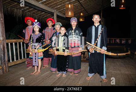 Eine Familie von Hmong-Musikern, Tänzern und Entertainern in Chiang Khong in der Provinz Chiang Rai, Nordthailand in farbenfrohen traditionellen lokalen Kostümen Stockfoto