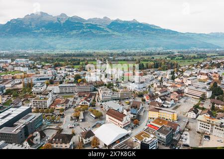 Ein Blick aus der Vogelperspektive von Vaduz, Liechtenstein, zeigt das Stadtbild eingebettet in eine Landschaft aus grünen Hügeln und Bergen Stockfoto