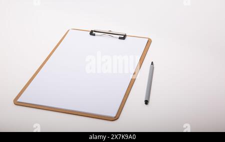 Hölzerne Zwischenablage mit weißem Papier, nachgebildet mit einem Stift Stockfoto