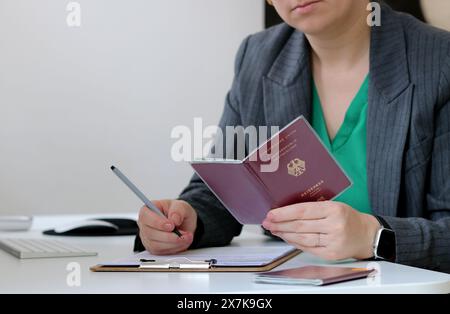 Nahaufnahme einer Frau mit deutschem Pass und Ausfüllen eines Visumantrags im Büro Stockfoto