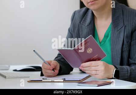 Nahaufnahme einer kaukasierin mit deutschem Pass und Ausfüllen eines Visumantrags im Büro Stockfoto
