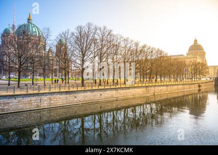 Das Berliner Schloss mit dem Humboldt-Forum sonnt sich im goldenen Licht des Sonnenuntergangs und spiegelt sich in den ruhigen Gewässern darunter. Berlin, Deutschland Stockfoto