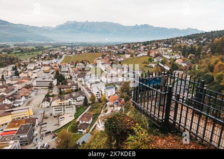 Eine Aussichtsplattform über der Stadt Vaduz, Liechtenstein, mit grünen Hügeln und einer Bergkette im Hintergrund Stockfoto