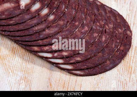 Dünne Scheiben katalanischer schwarzer Botifarra auf Holzhintergrund Stockfoto