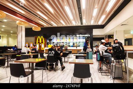 Auckland, Neuseeland - 21. Februar 2024: Reisende, die im McDonald's im Food Court im Auckland International Airport speisen. Stockfoto