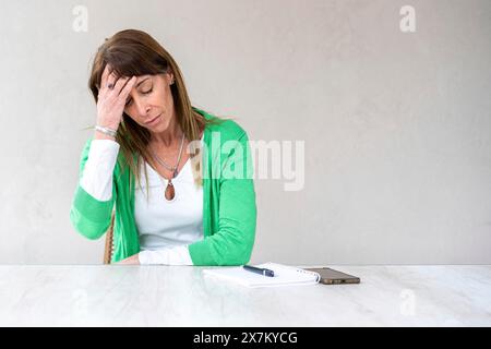 Eine Frau im mittleren Alter hält eine Hand auf der Stirn Stockfoto