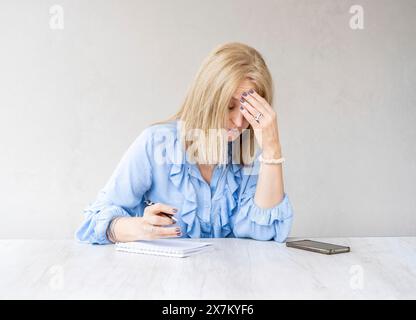 Müde Frau, die die Stirn berührt, mit Kopfschmerzen Migräne Stockfoto