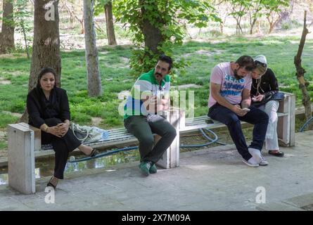 Ein junges iranisches Ehepaar, eine iranische Frau und ein iranischer Mann, der am 04/2015 auf einer Bank im tropischen Garten in Shiraz, Shiraz, Iran, saß Stockfoto