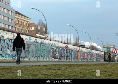 Ein Mann spaziert entlang der Überreste der Berliner Mauer, der East Side Gallery, 20/02/2014 Stockfoto