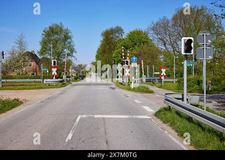 Eingezäunter Bahnübergang mit Verkehrsampel für Kraftfahrzeuge in Niebuell, Landkreis Nordfriesland, Schleswig-Holstein, Deutschland Stockfoto