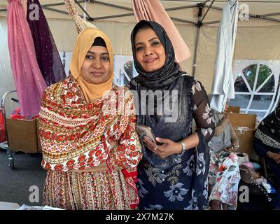 Frauen posieren für ein Porträt auf der Bangladeshi Street Fair im Kensington-Viertel von Brooklyn, New York. Es sind Anbieter, die Schals verkaufen. Stockfoto