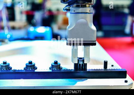 Modernes Roboterarm-Automatisierungssystem, das Metallgetriebeteile in der Fabrik bewegt, Industrieroboter-Konzept Stockfoto