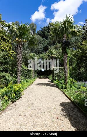 Eine sehr weit entfernte Aussicht auf den Happisburgh Lighthouse ist sorgfältig in die Gestaltung dieses Teils der Old Rectory Gardens in East Ruston, Norfolk, einbezogen Stockfoto