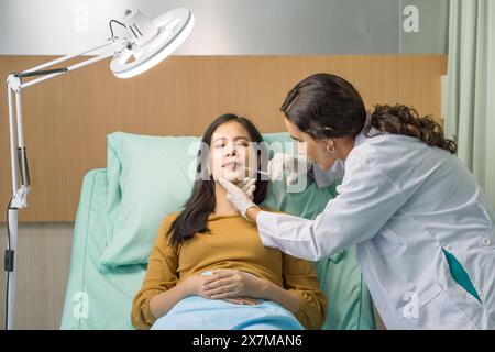 Arzt in weißem Kleid und Schutzhandschuh geben weibliche Patienten medizinische Injektion in die Lippe. Atmosphäre in der kosmetisch-chirurgischen Abteilung in der Krankenhausklinik Stockfoto