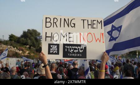 JERUSALEM - 20. MAI: Ein Demonstrant hält ein Schild mit der Aufschrift "bring sie jetzt nach Hause", während sich regierungsfeindliche Demonstranten zu einer Demonstration gegen Benjamin Netanjahus Regierung versammeln und neue Wahlen in der Nähe der Knesset, des israelischen parlaments am 20. Mai 2024 in Jerusalem fordern. Israel Stockfoto