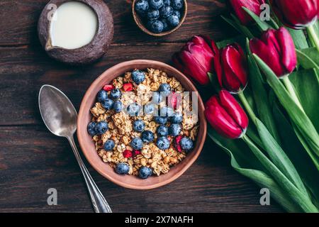 Müsli mit Kirschen und Heidelbeeren in einer Keramikschale Stockfoto