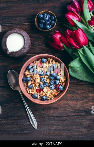 Müsli mit Kirschen und Heidelbeeren in einer Keramikschale Stockfoto