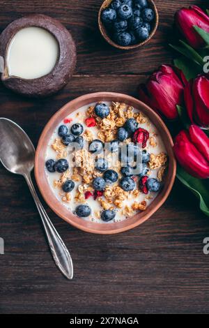 Müsli mit Kirschen und Heidelbeeren in einer Keramikschale Stockfoto