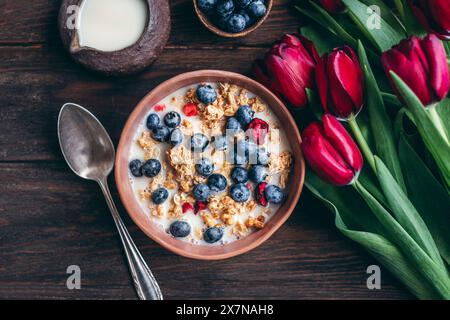 Müsli mit Kirschen und Heidelbeeren in einer Keramikschale Stockfoto