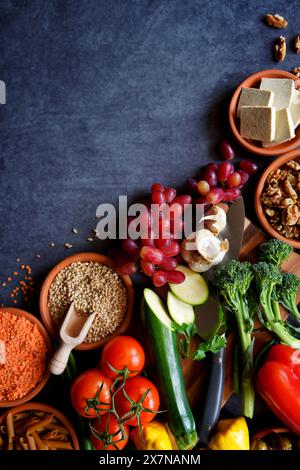 Pflanzliche Vollnahrungsrohstoffe einschließlich Obst, Gemüse, Körner, Hülsenfrüchte, Tofu und Nüsse. Stockfoto