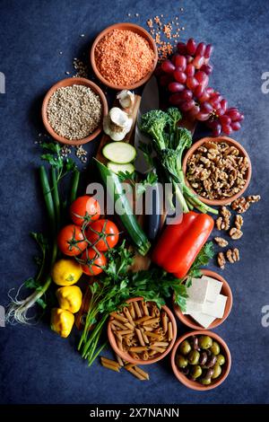 Pflanzliche Vollnahrungsrohstoffe einschließlich Obst, Gemüse, Körner, Hülsenfrüchte, Tofu und Nüsse. Stockfoto