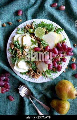 Salat im Waldorfstil mit Birnen, Walnüssen, Sellerie, Trauben und Baby-Raketenblättern. Nahaufnahme. Stockfoto